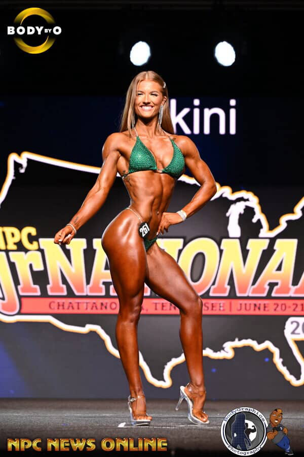 Female bikini competitor in a green suit at NPC Jr Nationals