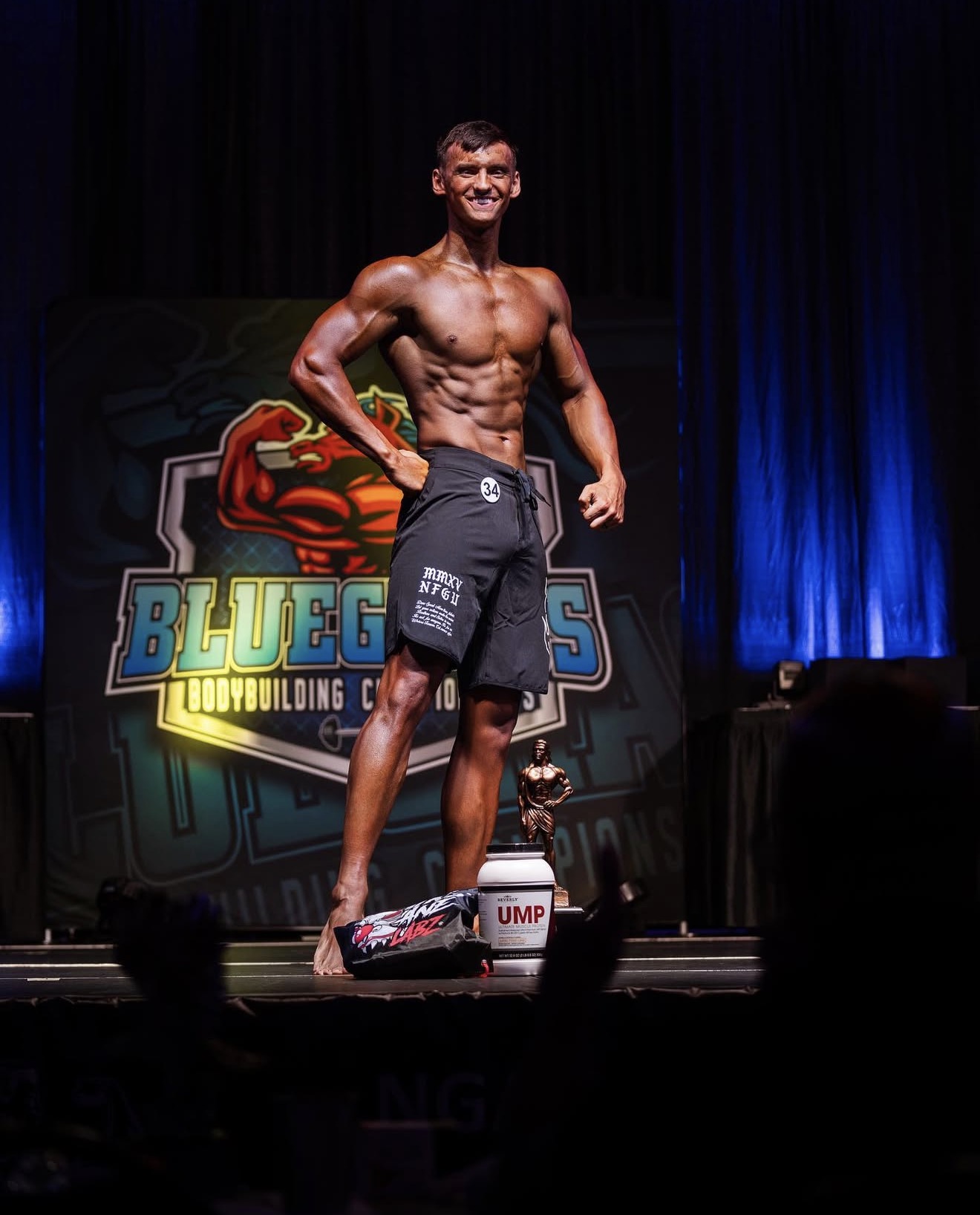 Male physique competitor with trophy at the Bluegrass championship