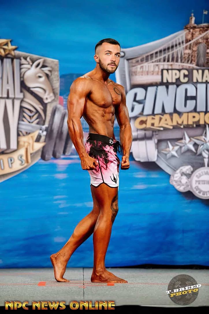 Male physique competitor side pose at NPC Cincinnati