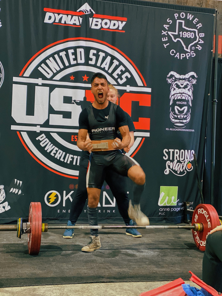 Male powerlifter roaring with a lifting belt at a USPC meet